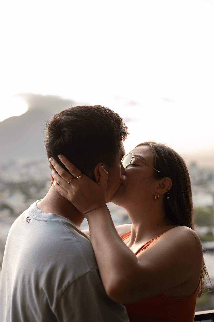 a couple kissing in front of a city view